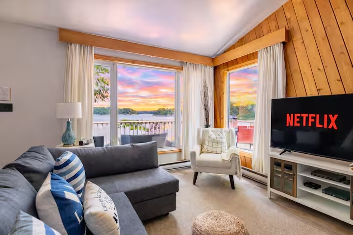 Living room with sunset lake panorama through floor-to-ceiling windows