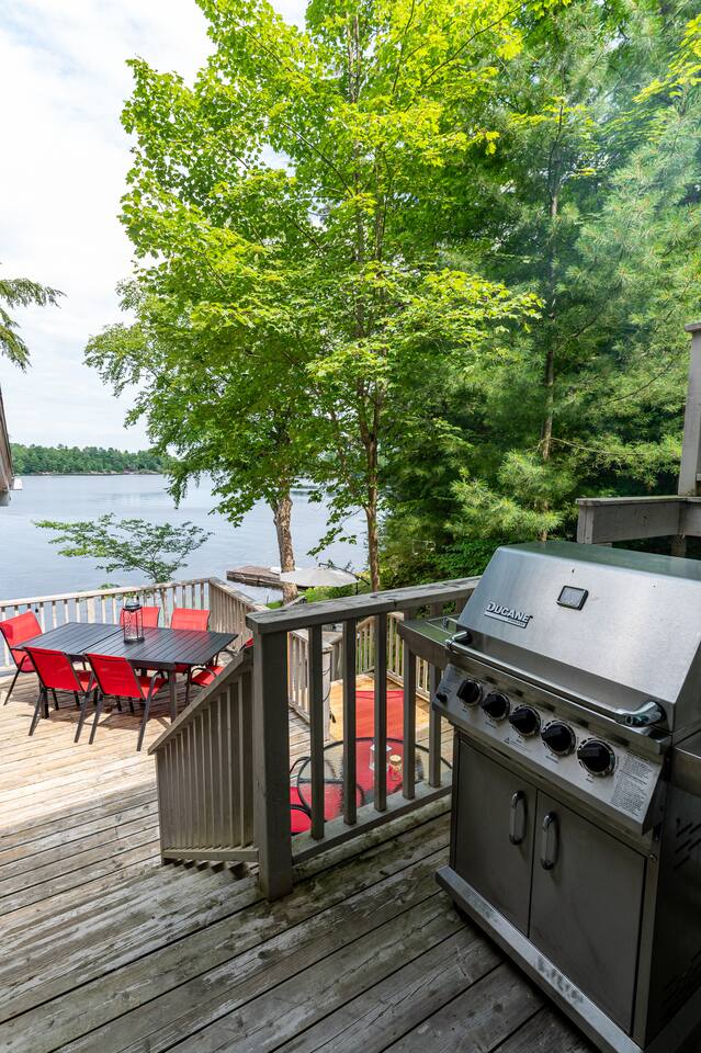 Multi-level deck with red outdoor furniture and panoramic lake views