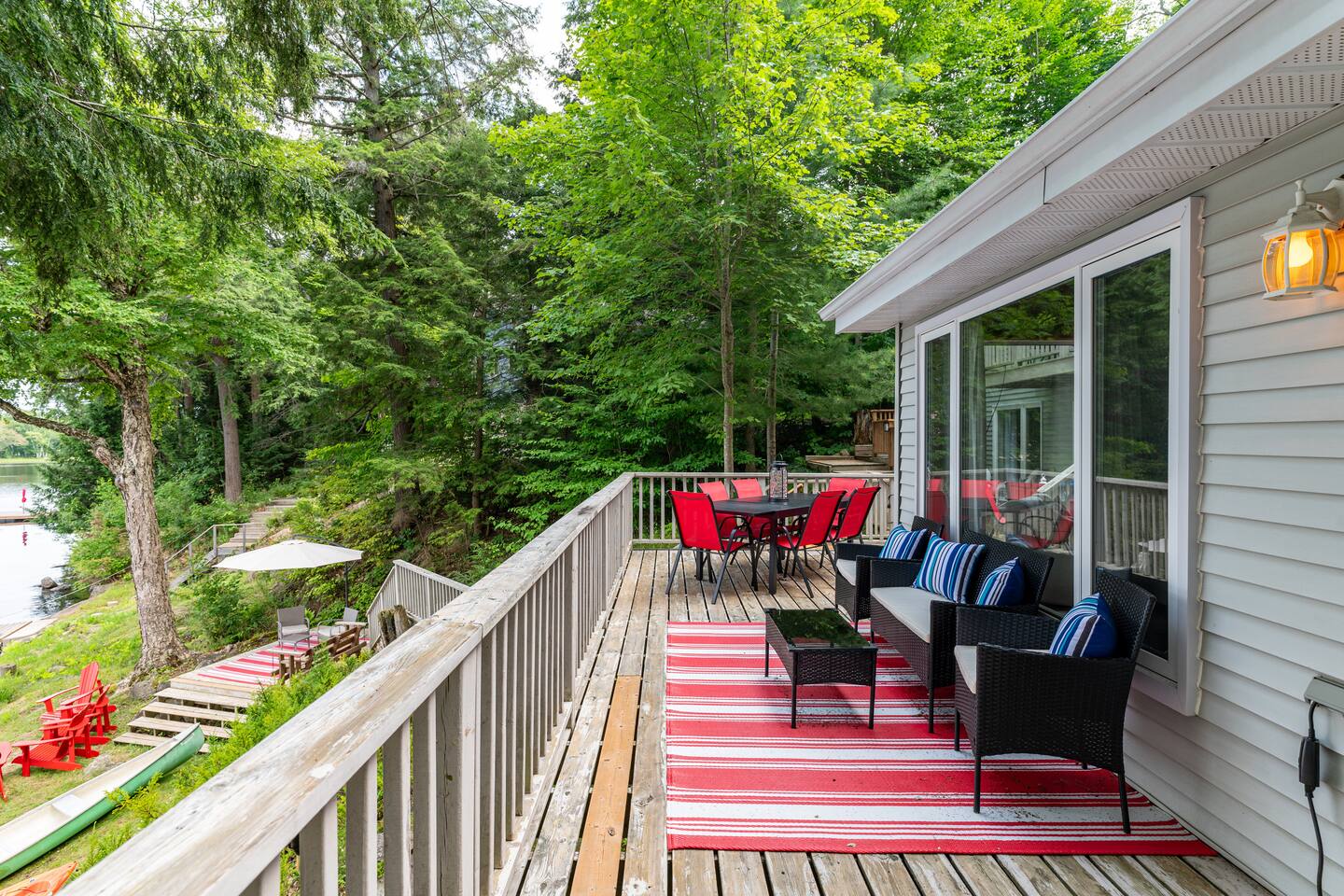 Aerial view of waterfront cottage with dock, kayaks and sandy shoreline